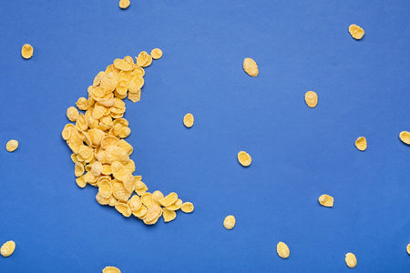 Moon made of tasty cornflakes on color background