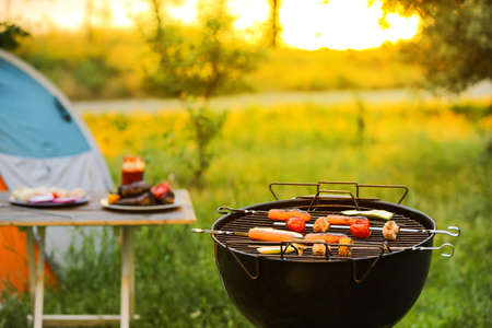 Barbecue grill with tasty sausages and vegetables outdoorsの写真素材