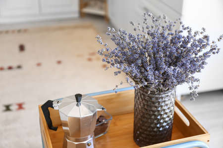 Vase with beautiful lavender flowers and coffee pot on table in kitchenの写真素材