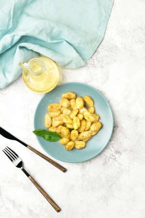 Plate with tasty pesto gnocchi on light backgroundの写真素材