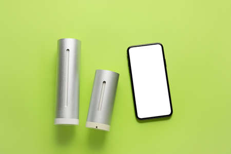 Digital weather station and mobile phone on green backgroundの写真素材