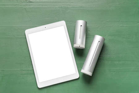 Home weather station and tablet computer on wooden background
