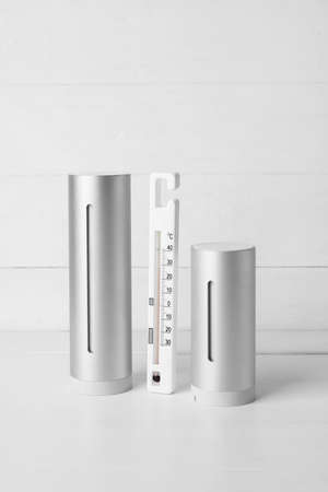 Digital weather station and thermometer on light wooden backgroundの写真素材