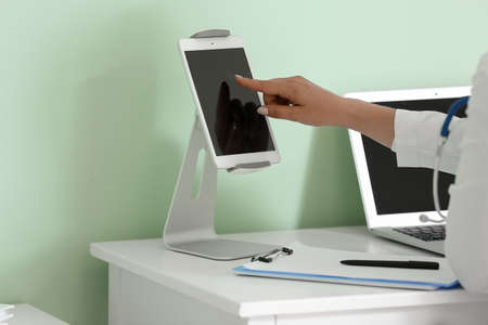 Female doctor using tablet computer at table in medical office