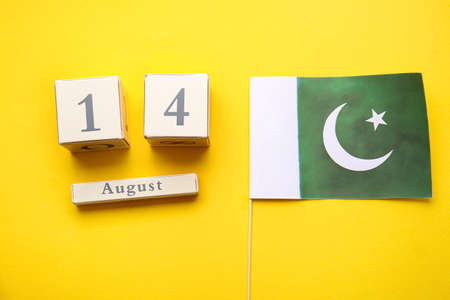 Flag of Pakistan and calendar with date of Independence Day on color background