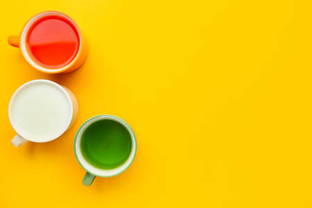 Cups with drinks in colors of Indian flag on yellow backgroundの写真素材