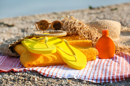 Bag with flip-flops and accessories on sea beachの写真素材