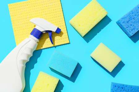 Cleaning sponges, rag and bottle of detergent on blue backgroundの写真素材