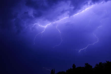 Dark sky with lightning over night city