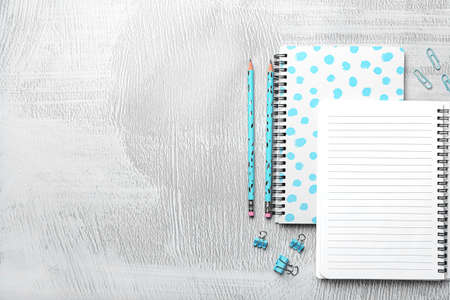 Blank notebook and stationery on light grunge background