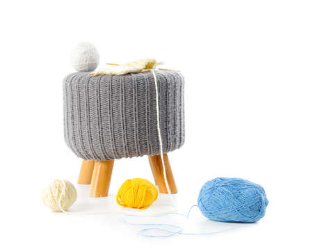 Gray ottoman with knitting yarn on white background