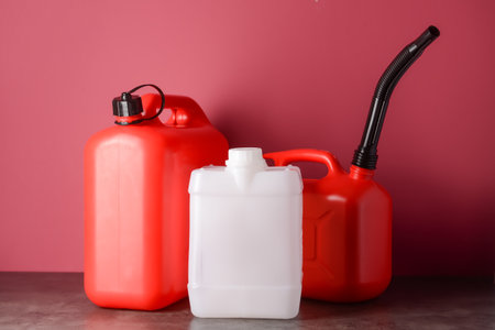 Plastic jerry cans on color background