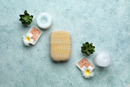 Bath sponge, candles and salt on color background