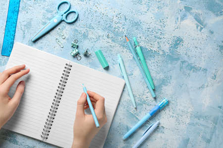 Woman with notebook and stationery on grunge background