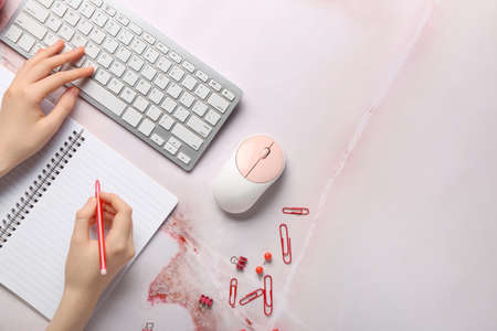 Woman writing in notebook while working on grunge background