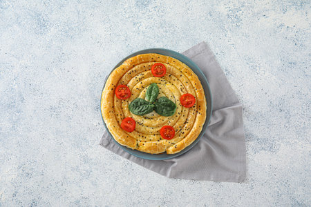 Plate with tasty spinach pie on light backgroundの写真素材