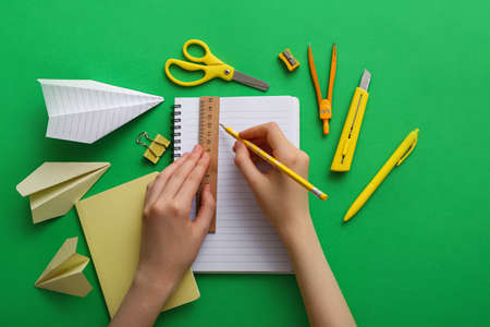 Woman with notebook and stationery on color backgroundの写真素材
