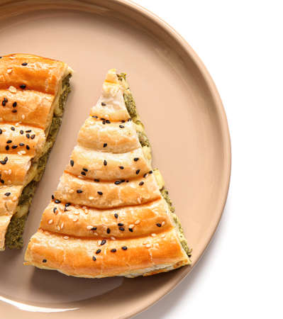 Plate with slices of tasty spinach pie on white background, closeup