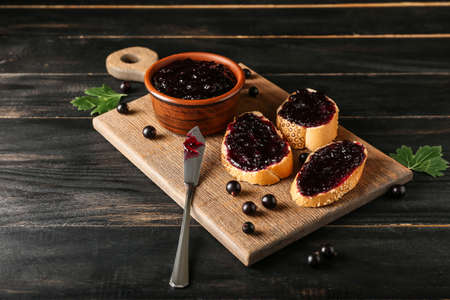 Toasts with black currant jam on dark wooden backgroundの写真素材