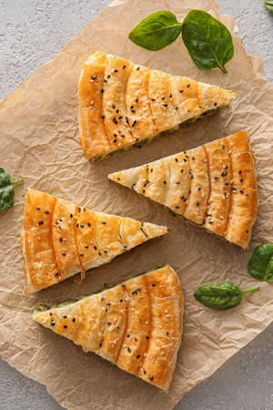 Slices of tasty spinach pie on light backgroundの写真素材