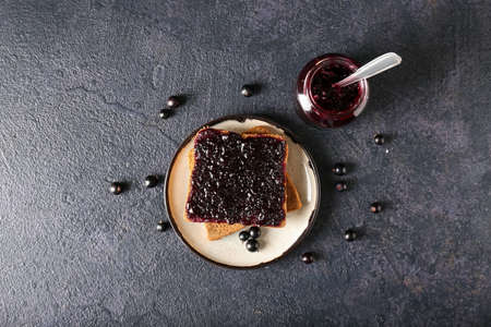 Toasts with black currant jam on dark backgroundの写真素材