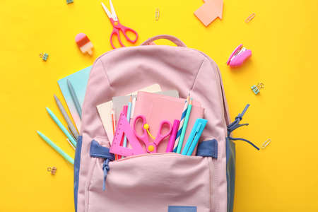 School backpack and stationery on color backgroundの写真素材