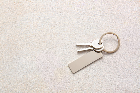 Keys with stylish keychain on light backgroundの写真素材