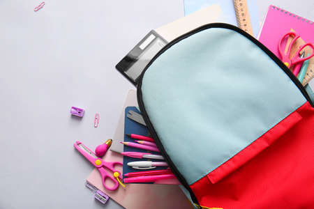 School backpack and stationery on light backgroundの写真素材