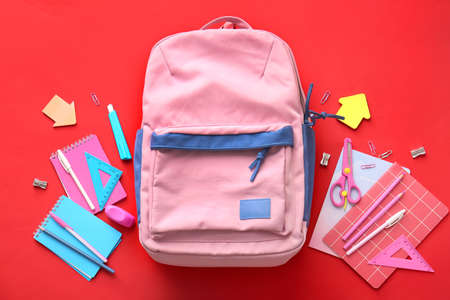 School backpack and stationery on color backgroundの写真素材