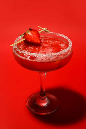 Glass of tasty strawberry margarita on color background
