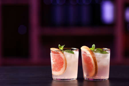 Glasses of tasty grapefruit margarita on table in barの写真素材