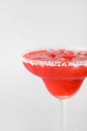 Glass of tasty strawberry margarita on white backgroundの写真素材