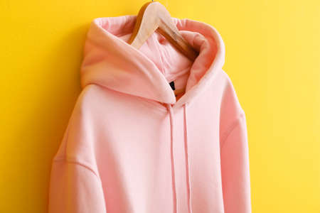 Modern hoodie hanging on color wallの写真素材