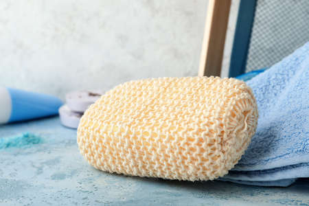 Loofah sponge with towels on table in light bathroomの写真素材