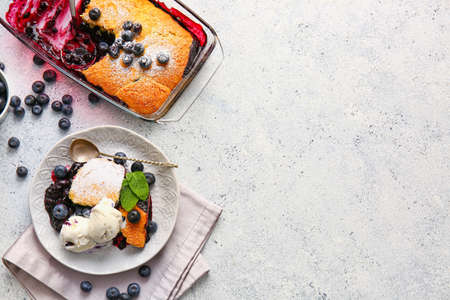 Composition with blueberry cobbler and ice cream on light background