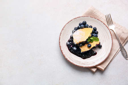 Plate with pieces of blueberry cobbler on light backgroundの写真素材