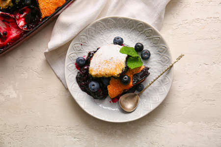 Plate with pieces of blueberry cobbler on light backgroundの写真素材