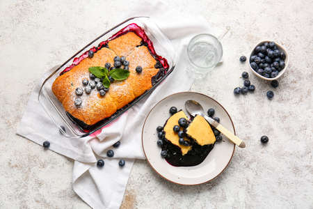 Composition with blueberry cobbler and glass of water on light background