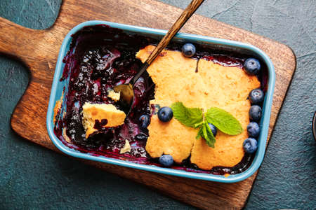 Baking dish with blueberry cobbler on dark backgroundの写真素材