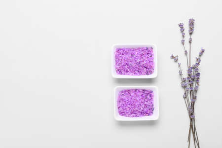 Bowls with sea salt and lavender flowers on white background