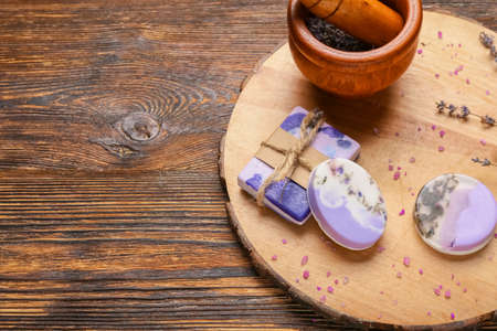 Composition with soap bars and lavender flowers on wooden background, closeup