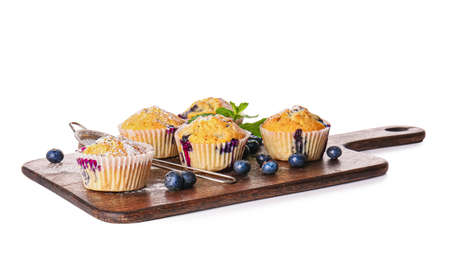 Board with tasty blueberry muffins on white background