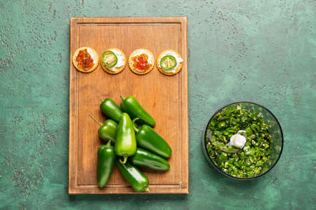 Blender and ingredients for delicious jalapeno pepper jam on color backgroundの写真素材