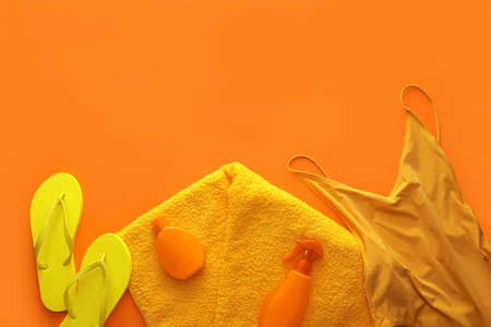 Set of beach accessories on color background