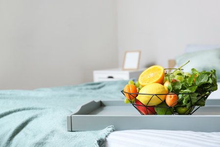 Tray with fruit basket on bed in roomの写真素材