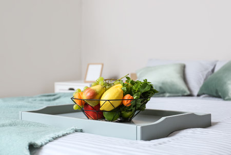 Tray with fruit basket on bed in roomの写真素材