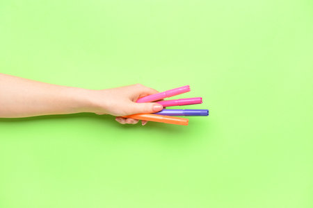 Female hand with colorful markers on color backgroundの写真素材