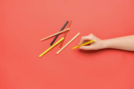 Female hand with colorful markers on color background