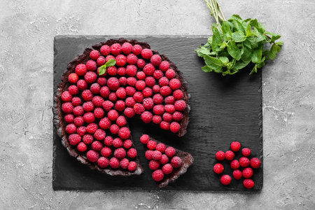 Slate board with tasty raspberry pie and mint on grunge backgroundの写真素材