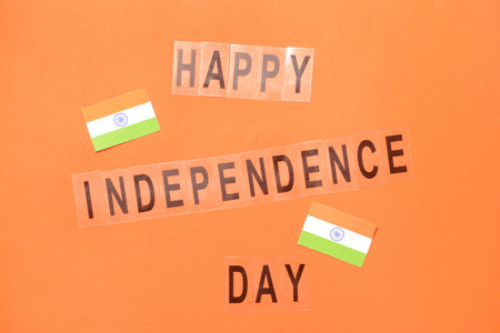 Indian flags and text HAPPY INDEPENDENCE DAY on color backgroundの写真素材